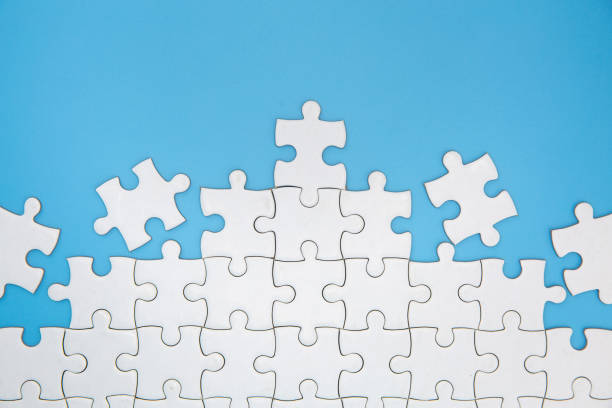 Unfinished white jigsaw puzzle pieces on blue background, The last piece of jigsaw puzzle, Copy space. Unfinished white jigsaw puzzle pieces on blue background, The last piece of jigsaw puzzle, Copy space. jigsaw puzzle photos stock pictures, royalty-free photos & images