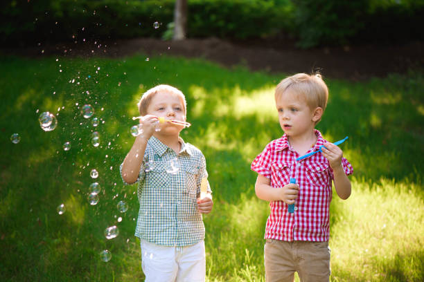 istock two happy boy play in bubbles outdoors 1166036890