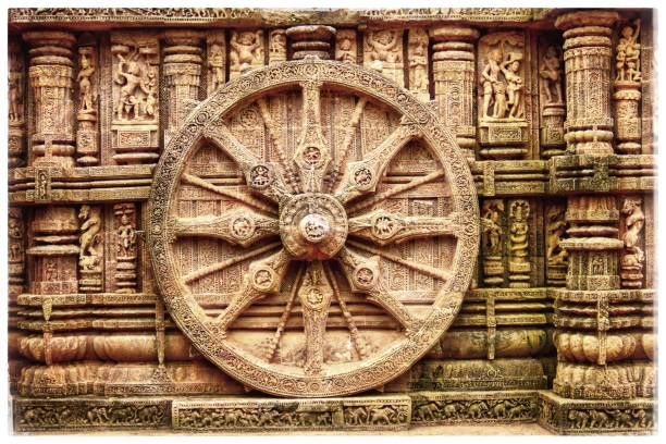The Wheel at the Konark Sun Temple. The 12 pairs of wheels signify the 24 hours of each day. The wheels could be used to calculate the exact time of the day based on the shadow falling  on the wheel. chariot wheel at konark sun temple india stock pictures, royalty-free photos & images