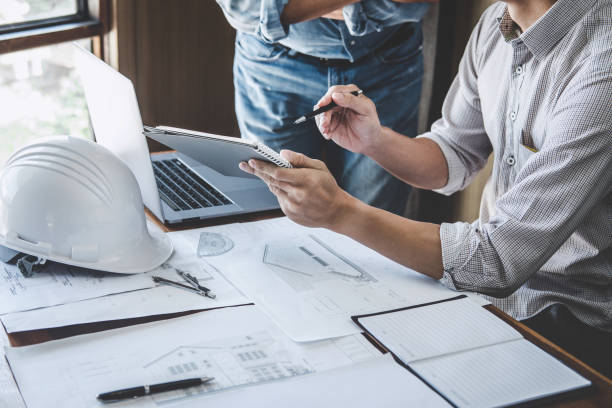 istock Engineer Teamwork Meeting, Drawing working on blueprint meeting for project working with partner on model building and engineering tools in working site, Construction and structure concept 1166037300