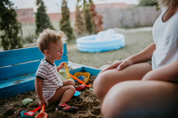 istock Child plays with his single mother in the sandbox 1166037391
