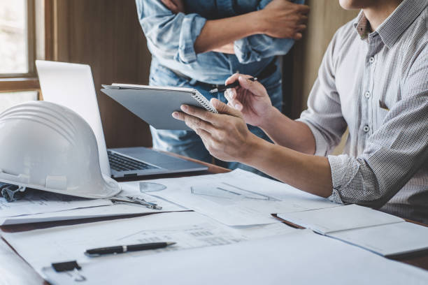 istock Construction and structure concept of Engineer or architect meeting for project working with partner and engineering tools on model building and blueprint in working site, contract for both companies 1166037401