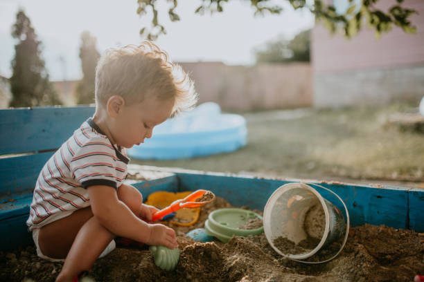 Child plays with his single mother in the sandbox Child plays with mother and enjoys his childhood sandbox stock pictures, royalty-free photos & images