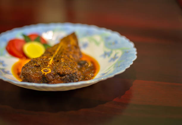 Cooked Chital Fish/ Chitol mach Top view of Cooked Chital Fish/ Chitol mach garnished with Tomato and lemon slice. Selective Focus is used. chitala stock pictures, royalty-free photos & images