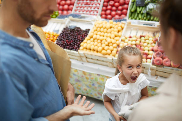 Girl Throwing Tantrum in Supermarket High angle view at spoiled little girl screaming at parents in supermarket, copy space brat stock pictures, royalty-free photos & images