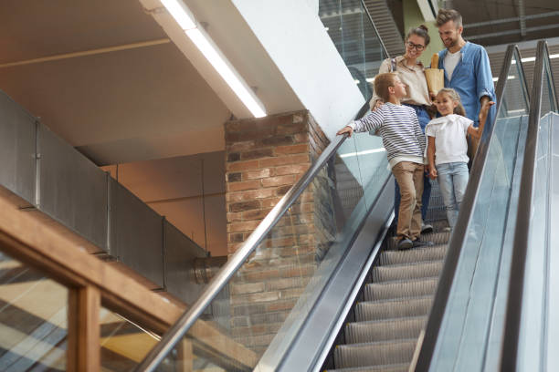 Family with Two Kids Going Down Escalator