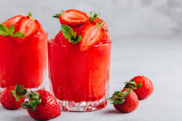 Fresh strawberry rhubarb and watermelon granita with mint on gray stone background