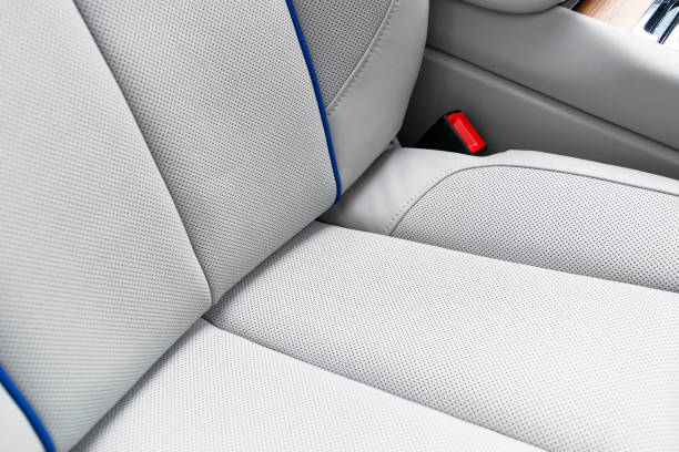 istock White leather interior of a car. Perforated white leather comfortable seats with stitching isolated on black background. Car interior details. Car detailing. Car inside 1166044232