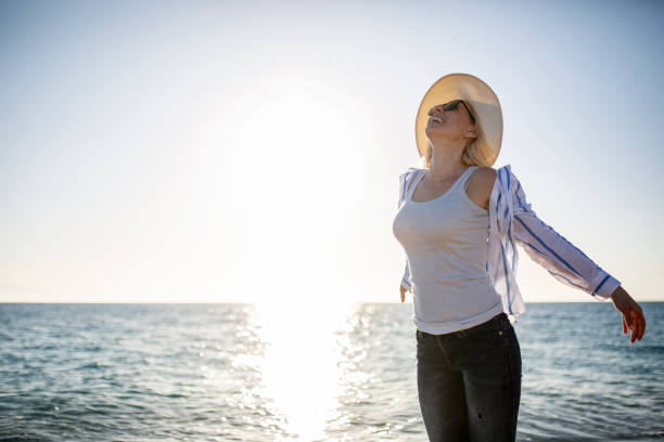 istock Woman watching sunset by the sea 1166045570