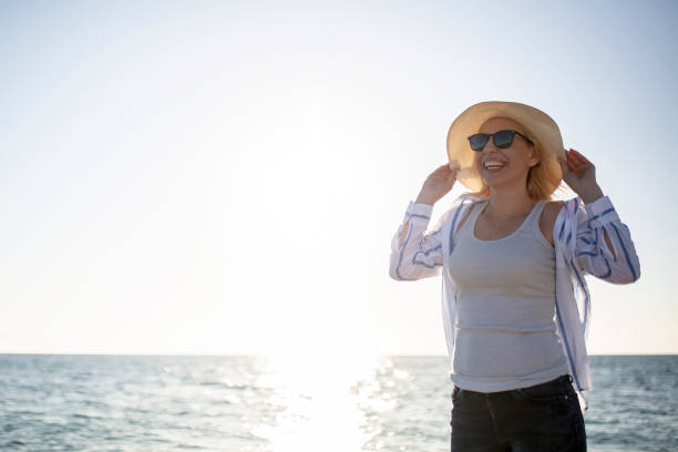 istock Woman watching sunset by the sea 1166046250
