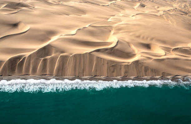 vista aérea de las dunas de la costa del esqueleto que se encuentran con el océano atlanic. - ee fotografías e imágenes de stock