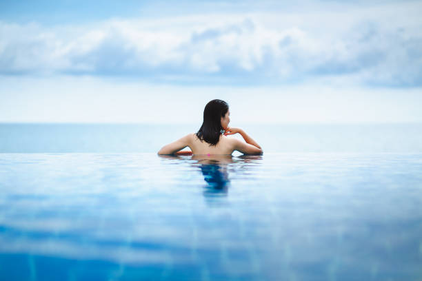 istock Asian woman relax in pool on beach 1166051461