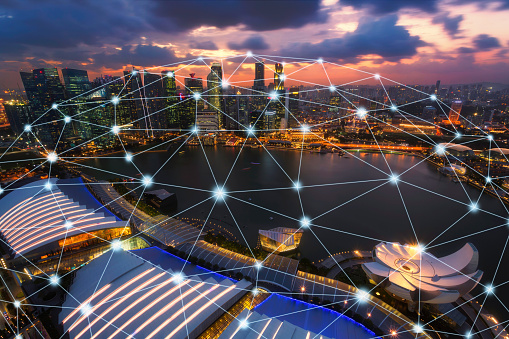 Network and Connection technology concept with Singapore city skyline at sunset in Marina Bay, panorama view