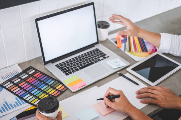 istock Teamwork of young creative designers working on project together and choose color swatch samples for selection coloring on digital graphic tablet and equipment at workplace 1166053232