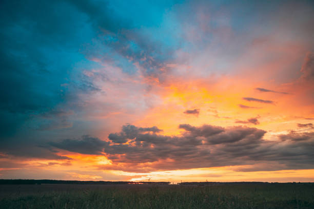 istock Spring Summer Meadow At Evening Sunset Sunrise. Natural Bright Dramatic Sky In Different Colours Above Countryside Meadow Landscape. Agricultural Landscape In May 1166054890