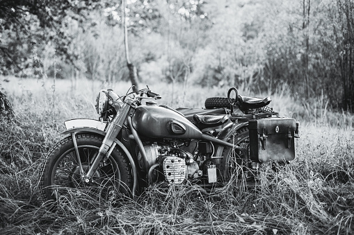 Old Tricar, Three-Wheeled Motorbike Of Wehrmacht, Armed Forces Of Germany Of World War II Time In Summer Forest. Photo In Black And White Colors.
