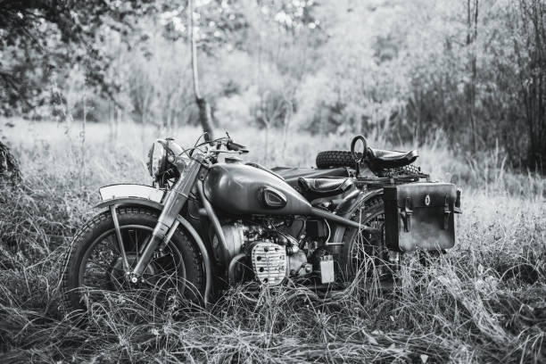 Old Tricar, Three-Wheeled Motorbike Of Wehrmacht, Armed Forces Of Germany Of World War II Time In Summer Forest. Photo In Black And White Colors Old Tricar, Three-Wheeled Motorbike Of Wehrmacht, Armed Forces Of Germany Of World War II Time In Summer Forest. Photo In Black And White Colors. sidecar photos stock pictures, royalty-free photos & images