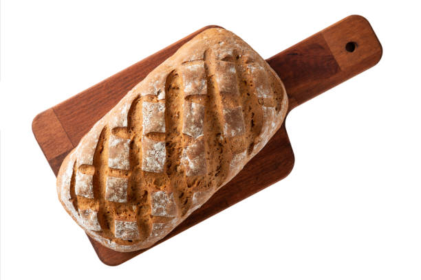 Loaf of bread on a cutting board isolated on white background top view stock photo