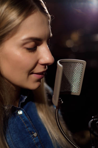 istock Blonde singing woman in a recording studio 1166062493