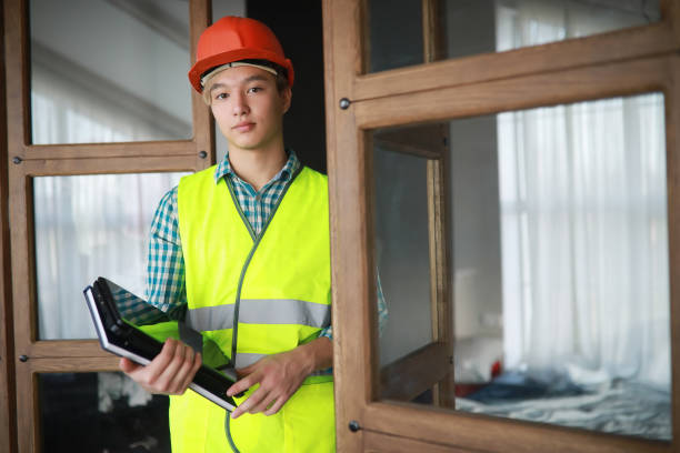 istock Asian man in protective helmet and construction waistcoat 1166064246