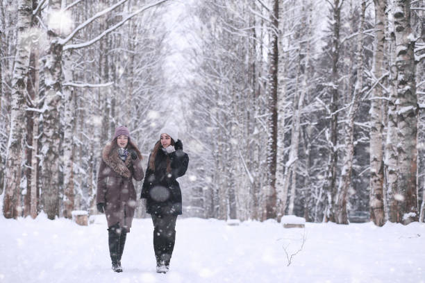 istock Girl in a winter park in snowfall 1166064313