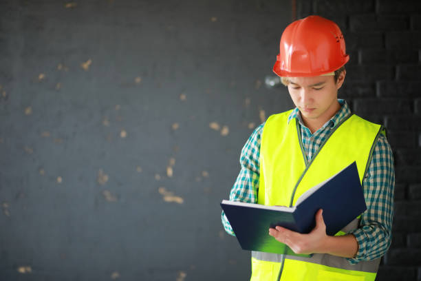 istock Asian man in protective helmet and construction waistcoat 1166064432