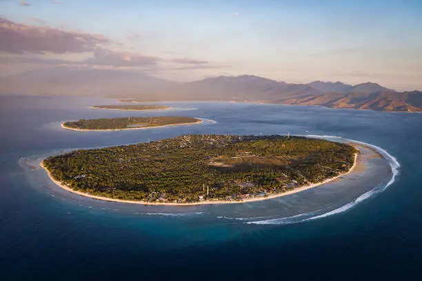Aerial view of the Gili Islands off the coast of Lombok, Indonesia, at sunset. The Gilis are the most popular tourist destination in Lombok.