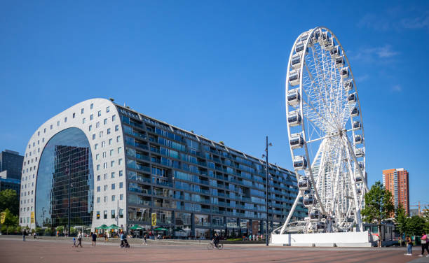 Markthal Rotterdam, Netherlands. Ferris wheel and people walking around. Rotterdam, Netherlands. June 27, 2019.  Market Markthal exterior view, ferris wheel and people, spring sunny day park designer label stock pictures, royalty-free photos & images