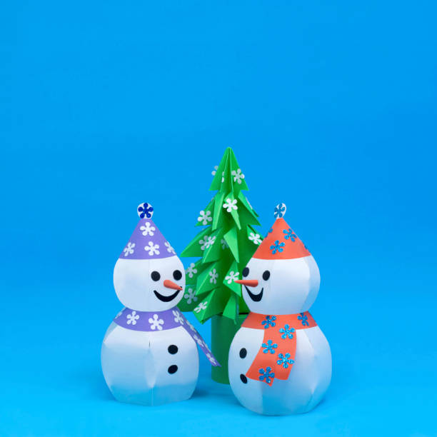 istock Two 3d paper snowmen and origami christmas tree 1166071950