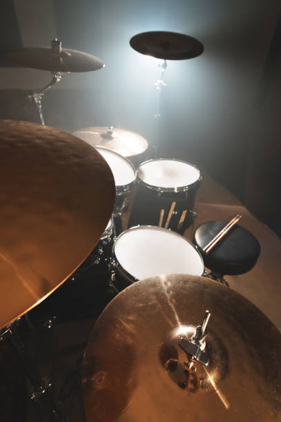 istock Modern drum set prepared for playing in a dark rehearsal room on stage with a bright spotlight. 1166072087