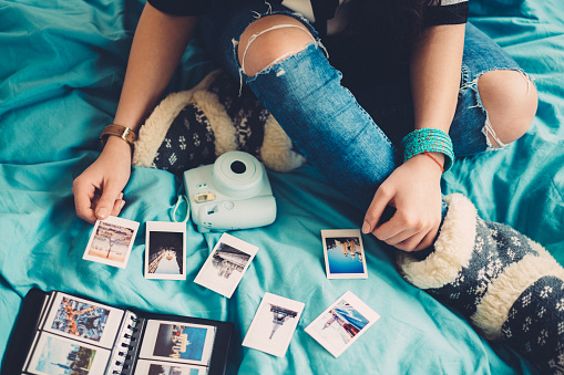 Woman in bed arranging travel photos