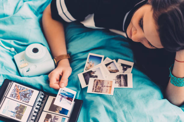 Europe trip Woman in bed arranging travel photos wonderlust stock pictures, royalty-free photos & images