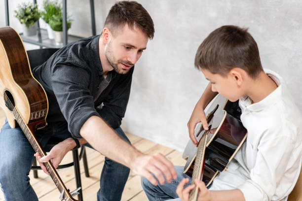 istock A personal tutor explains to his young student how to play studied chord correctly. Musical education at home 1166074852