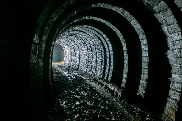 istock Dark dirty abandoned uranium mine with rusty remnants of railway 1166075372