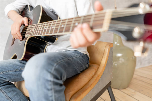 istock Young male hands playing acoustic guitar. Musical instruments 1166076871