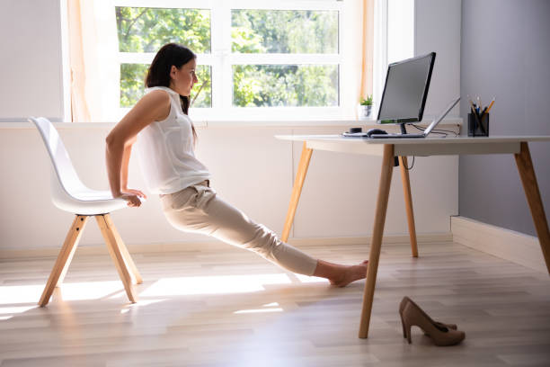 Businesswoman Doing Stretching Exercise Side View Of A Young Woman Doing Stretching Exercise In Office office competition stock pictures, royalty-free photos & images