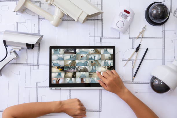 istock Watching Footage On Laptop With Security Equipment On Blueprint 1166079317