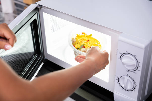istock Person Heating Food In Microwave Oven 1166079413