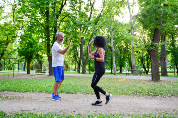istock Man saying hi to woman while jogging on the trim path 1166088363