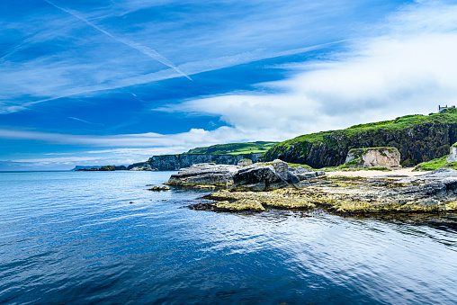 Coastal rocks with a very calm sea and blue sky, Northern Ireland