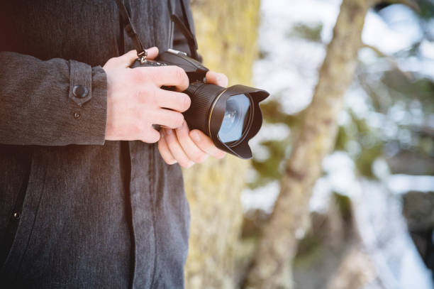 istock Close-up professional digital mirror camera in male hands in the winter forest. 1166088713