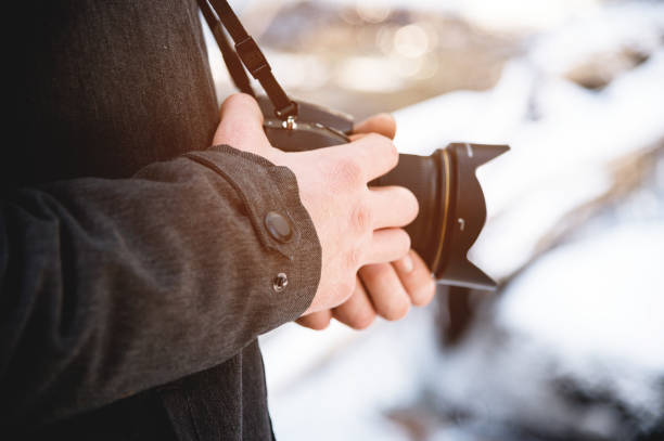 istock Close-up professional digital mirror camera in male hands in the winter forest. 1166089505