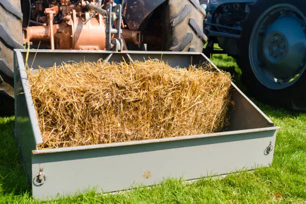 Photo of Bale of hay in the rear loader on a classic Massey Ferguson tractor