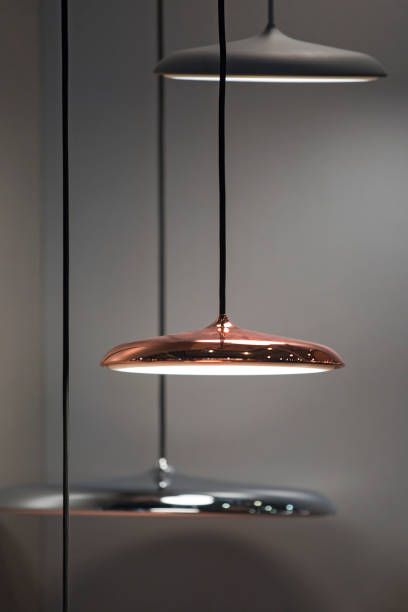 istock Different modern streamlined mirror copper chandeliers. Metal copper disk shaped pendant lamps. Loft style 1166092539