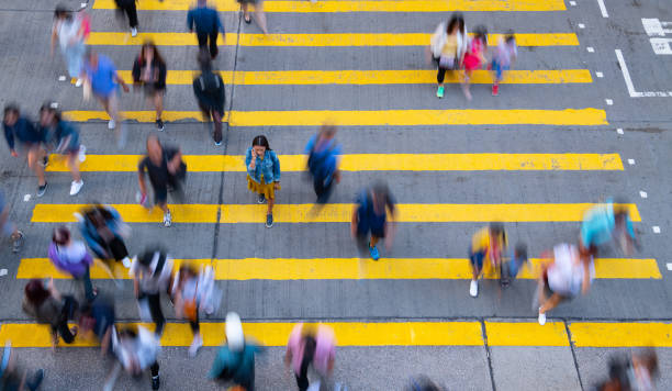 istock Young woman standing out, with phone, in motion blurred crowd 1166094855