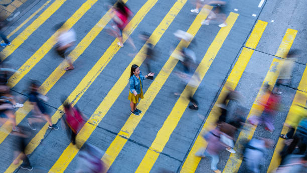 istock Young woman standing out, stationary in motion blurred crowd 1166095506