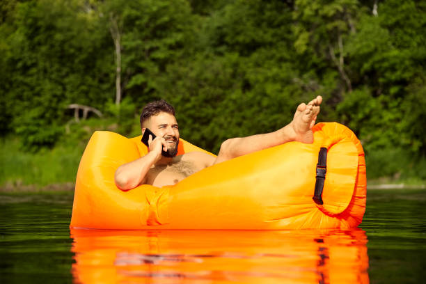 istock Young businessman on air sofa with phone. 1166097568