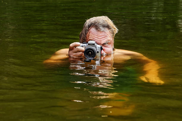 istock Taking photos by mature man in water. 1166097592