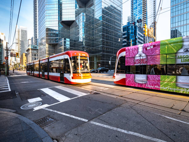 Toronto Mass Transit - Street Cars Toronto, Ontario, Canada - July 29, 2019:  Public transportation in Downtown Toronto.  Street Cars (electric power) pass each other (each going opposite directions) along King Street. sustainable energy toronto stock pictures, royalty-free photos & images