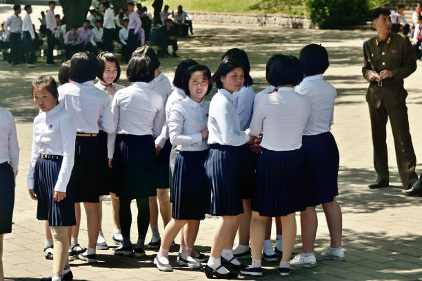 Pyongyang, North Korea. Girls Pyongyang, North Korea - May 1, 2019: Young girls, members of the Kimilsungist-Kimjongilist Youth League on a city street socialist symbol stock pictures, royalty-free photos & images